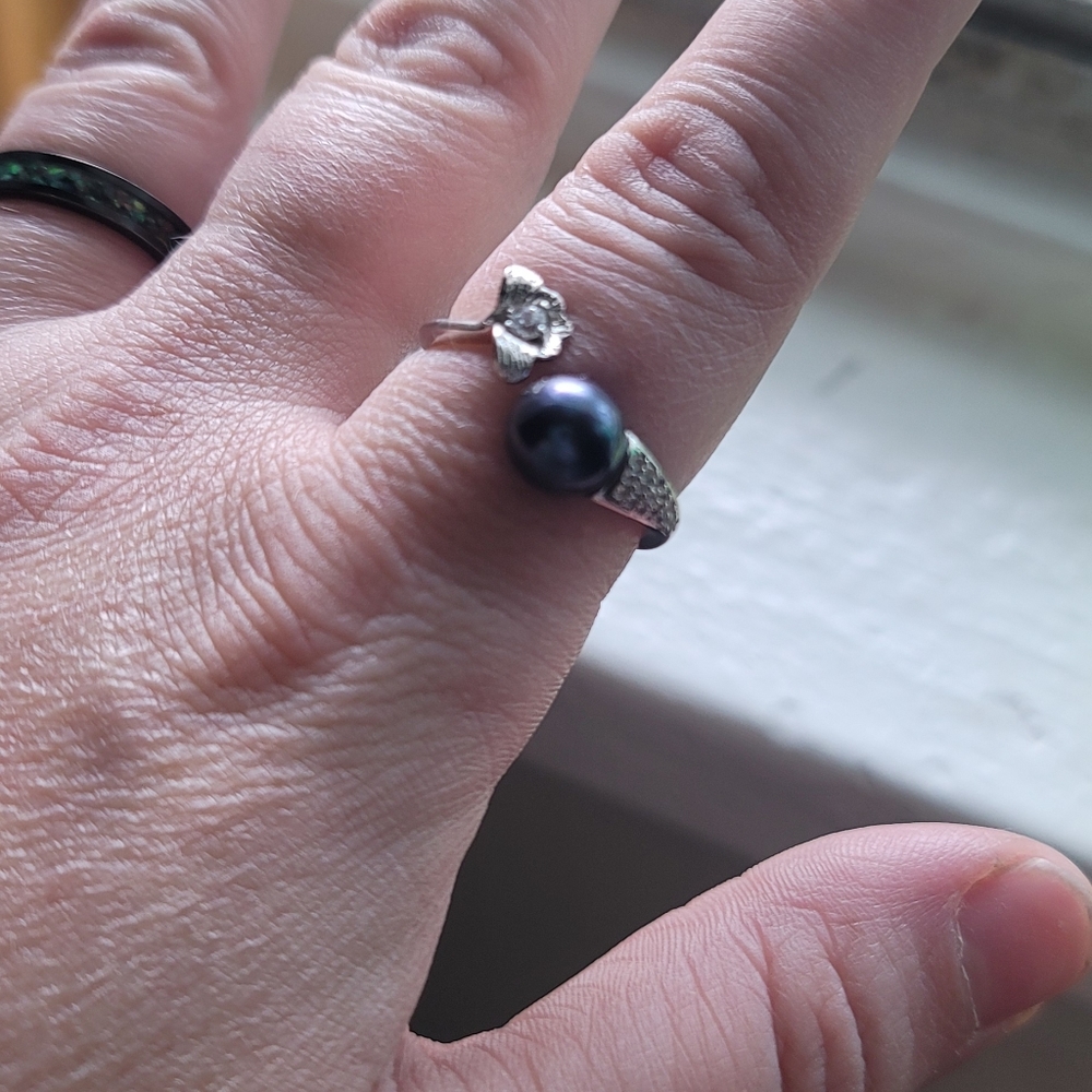 Dark blue like navy color adjustable pearl ring. Very pretty with cubic zirconia